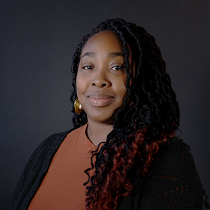 Simone in front of dark backdrop